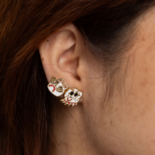 Cat and dog mismatched cloisonné stud earrings by Kristina Micotti worn on ear by Yellow Owl Workshop