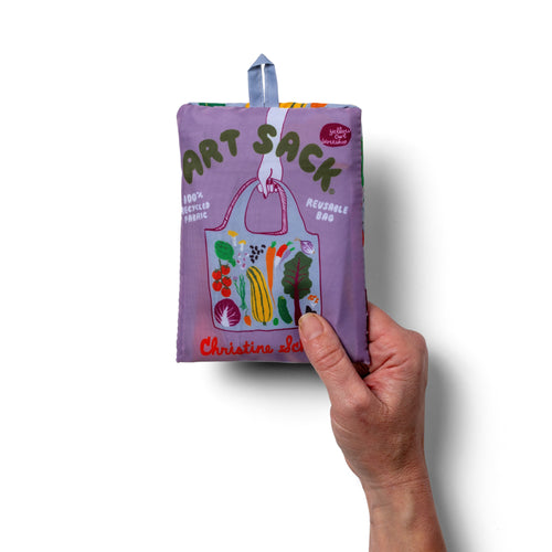 Person holding periwinkle illustrated farmers market tote bag with bold colorful vegetable print by Yellow Owl Workshop