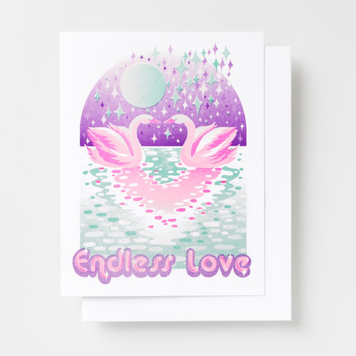 Risograph greeting card with two illustrated pink swans facing each other on a sparkling moonlit lake with a purple sky full of stars and diamonds, text reads Endless Love in pink bubble lettering