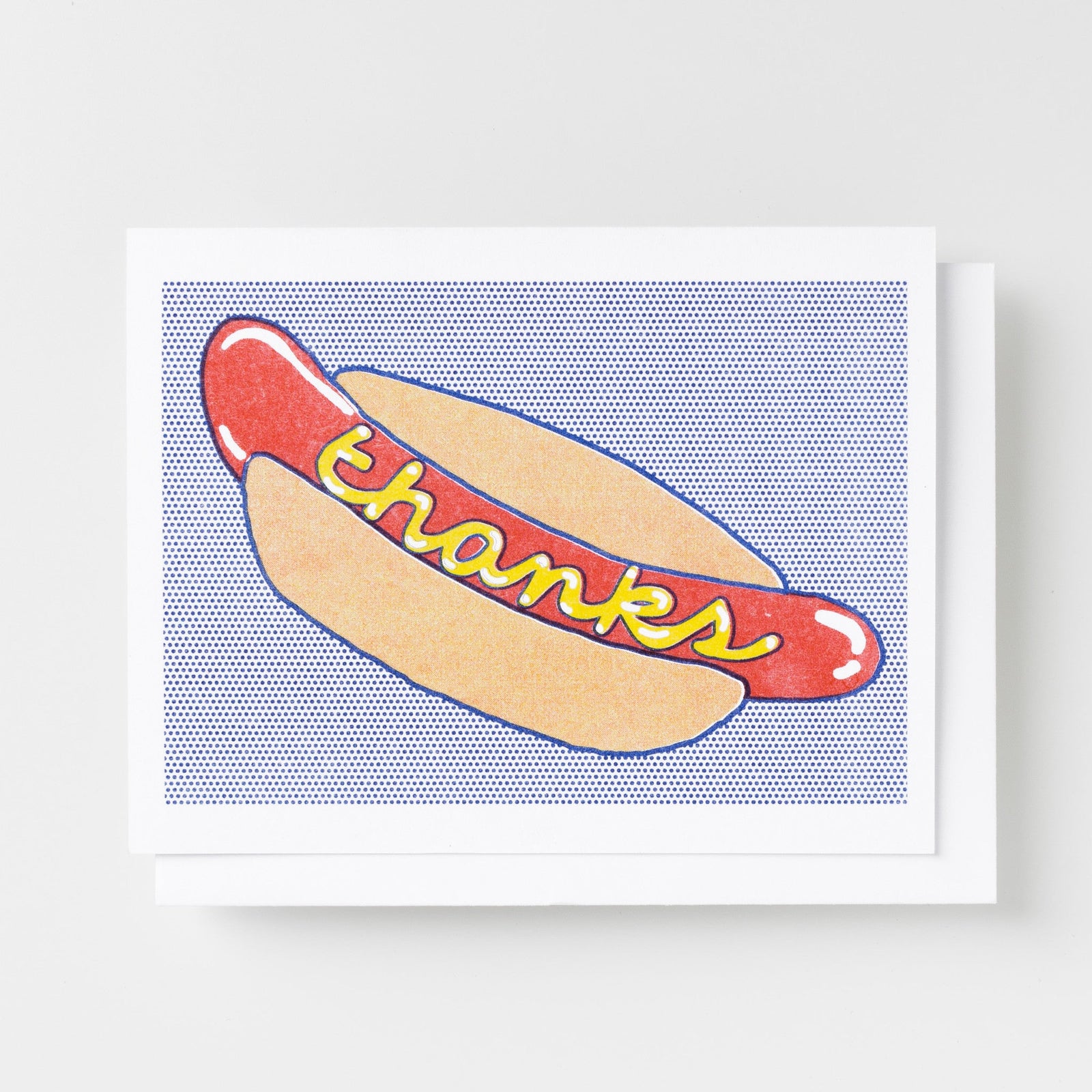 Risograph greeting card with an illustrated hot dog in a bun with mustard spelling out thanks on a blue halftone dot background