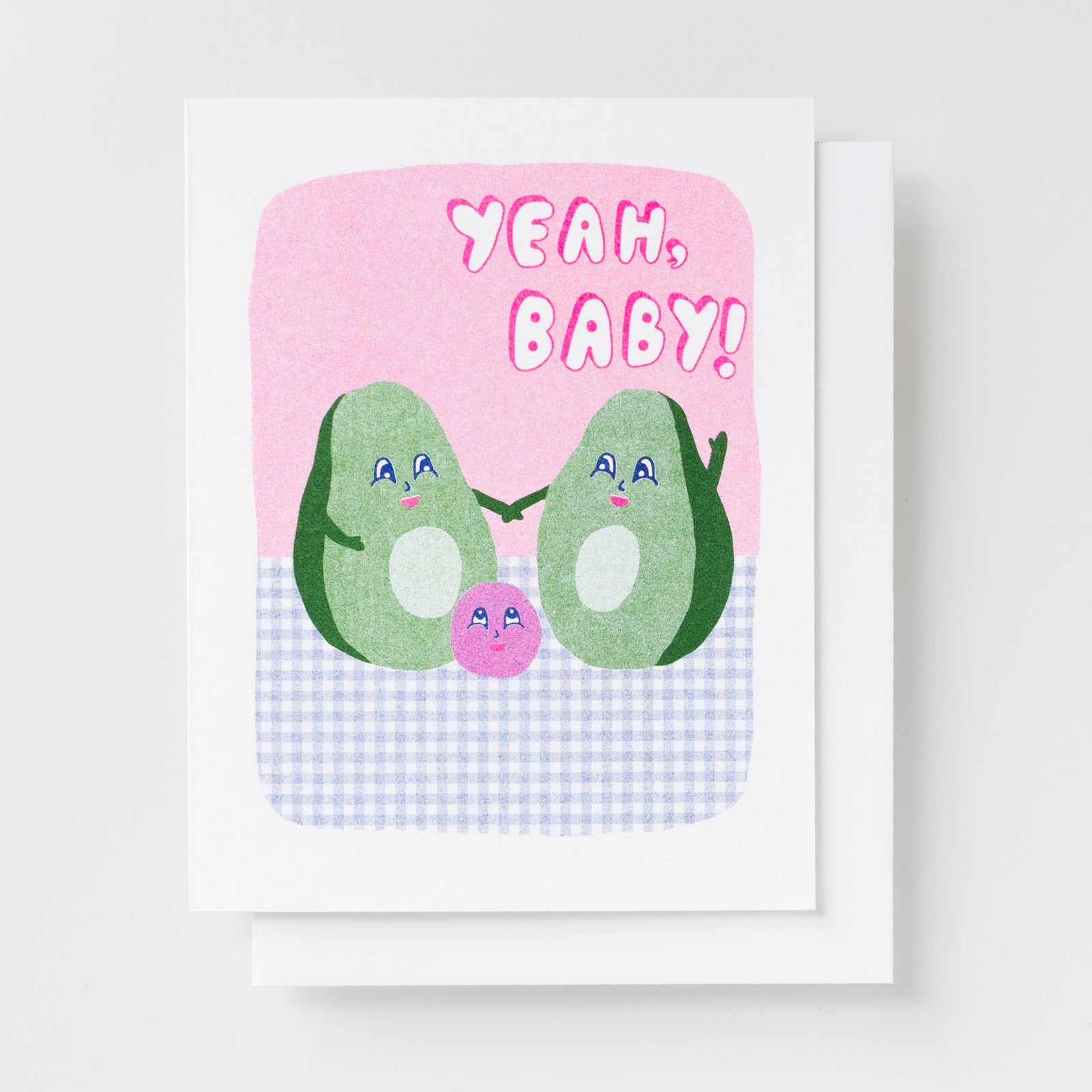 Risograph greeting card with two illustrated avocado characters holding hands with a small pink avocado pit between them on a pink and gingham background, text reads Yeah Baby in bold pink lettering